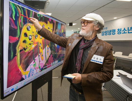 김종수 한국미술협회 부이사장이 지난 23일 서울 서초동에 위치한 삼성생명 대강의장에서 삼성 QLED 8K TV를 활용해 삼성생명이 주최하는 '제39회 청소년 미술대회' 예선 작품을 심사하고 있다. <삼성전자 제공>